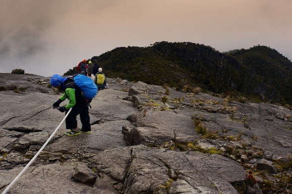 Descending the mountain with the help of an old piece of rope that has been string up along most of the route to the summit