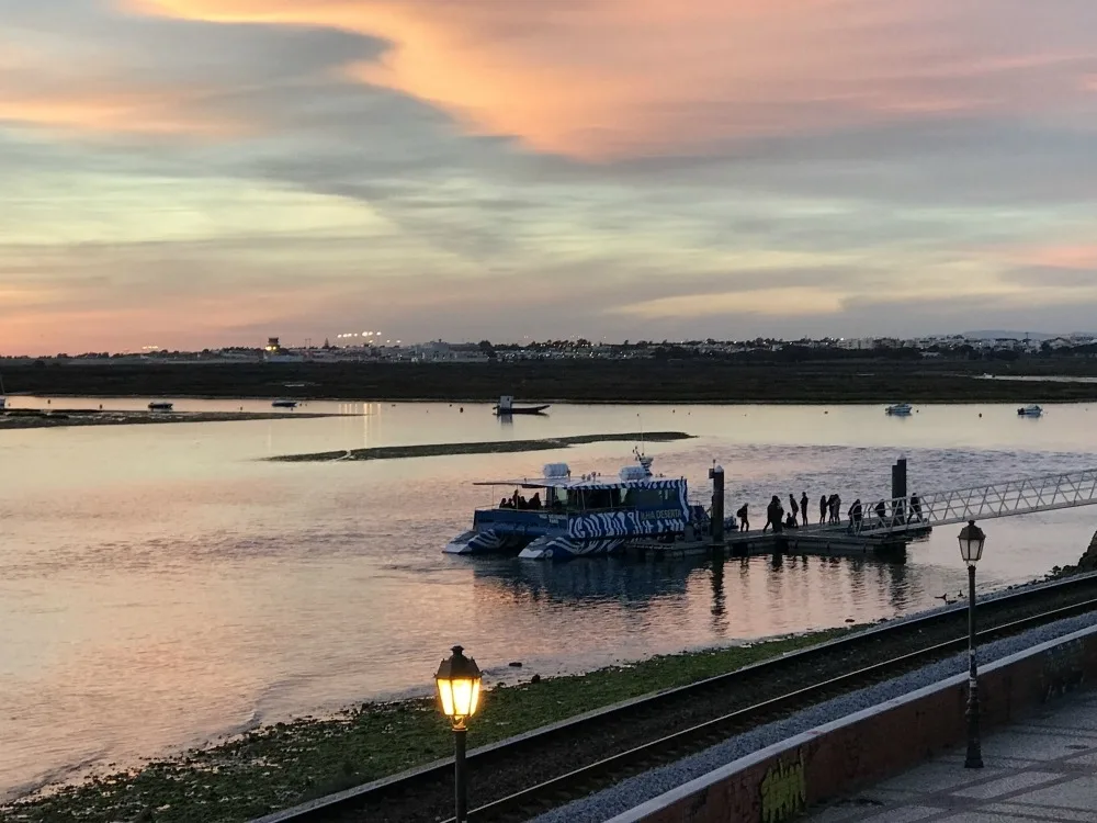 Boats arrive from Ria Formosa lagoon at sunset in Faro